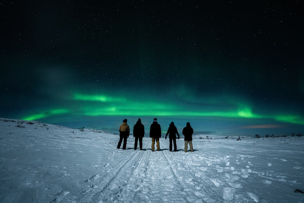 a group of people standing on top of a snow covered slope