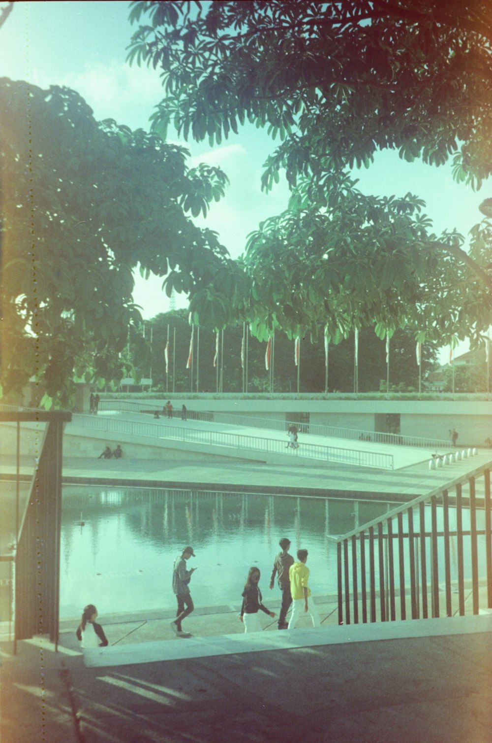 a group of people walking across a bridge over a river