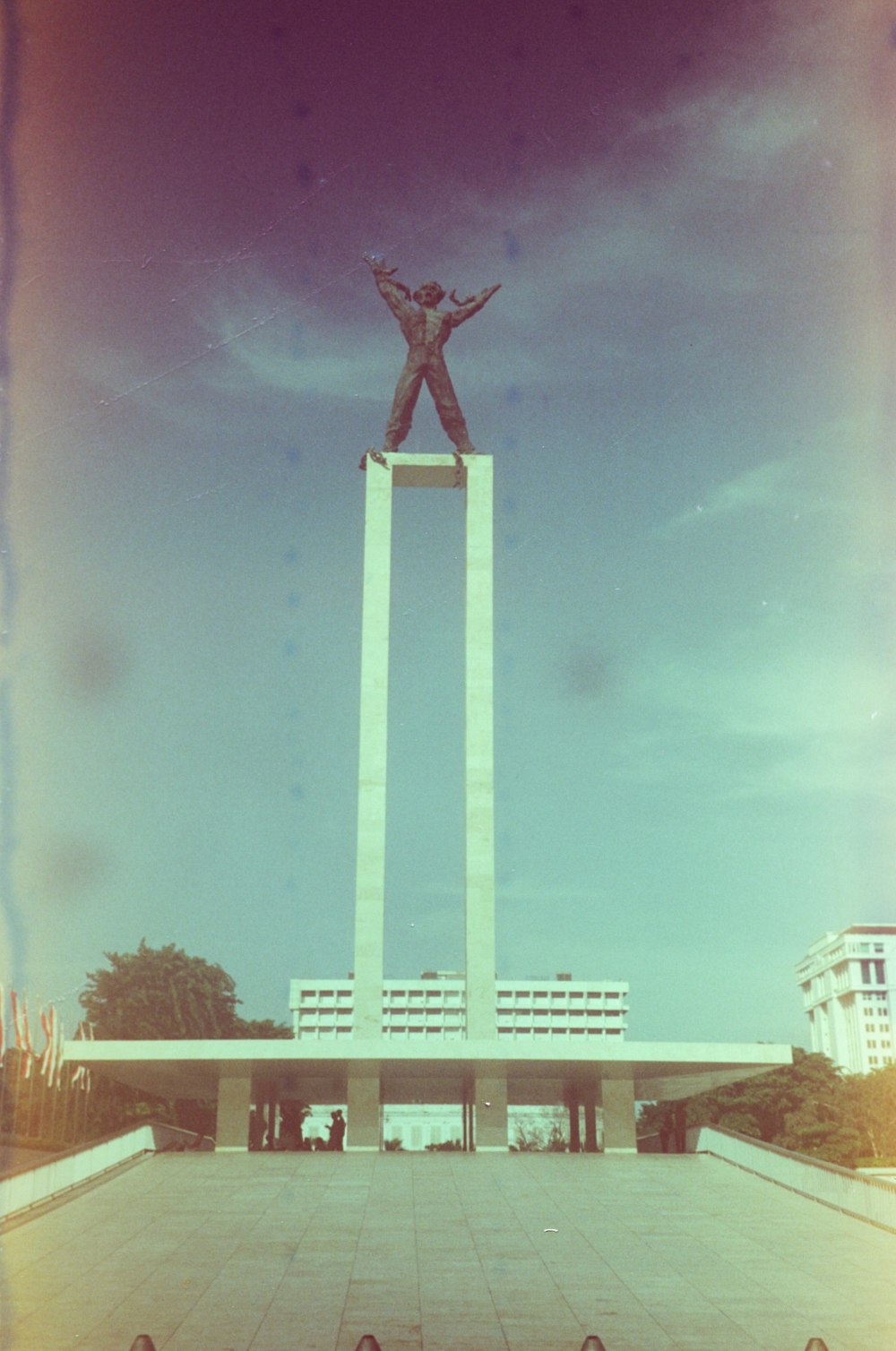 a statue of a man standing on top of a tall pillar