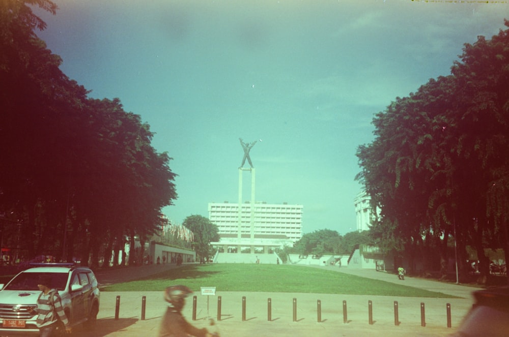 a man riding a bike down a street next to a tall building