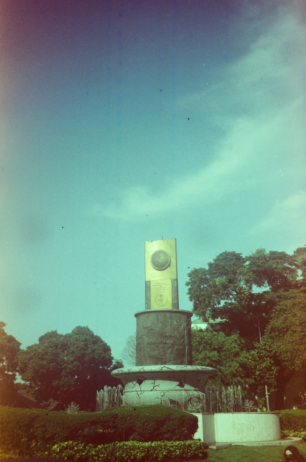 a tall clock tower sitting in the middle of a park