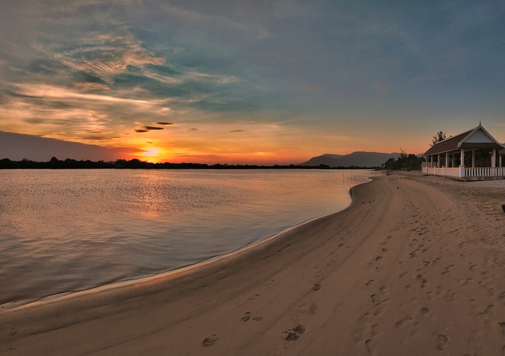 a beach with a gazebo and footprints in the sand