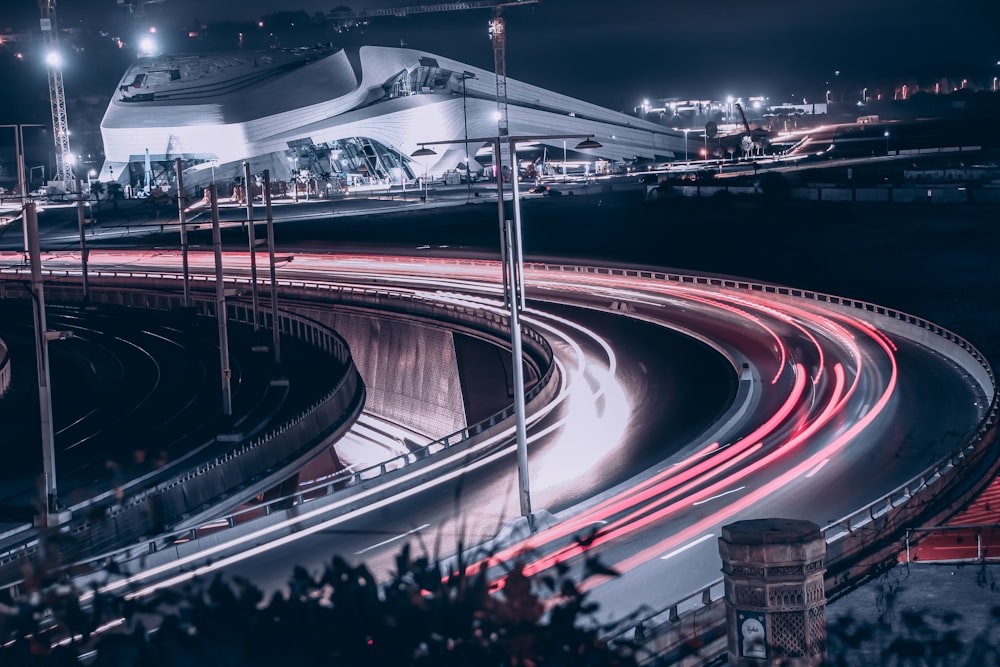 a night time view of a highway with a building in the background