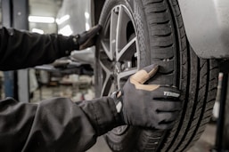 Technician carefully inspecting a tire in the well-organized service bay.