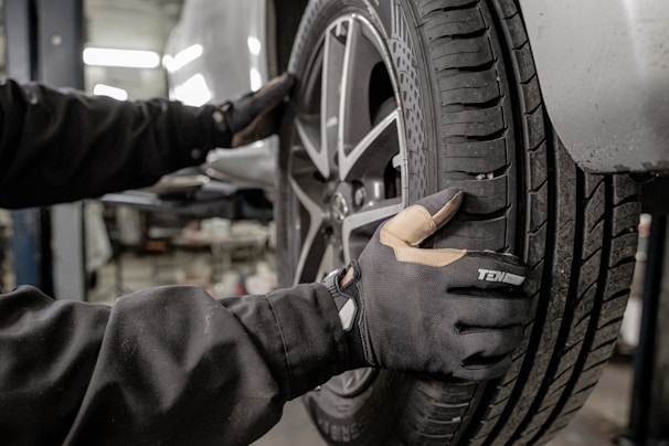 A truck tire being mounted on a vehicle in a garage.