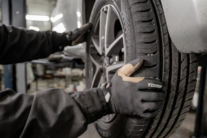 Khalid Omar changing a car tire in the workshop