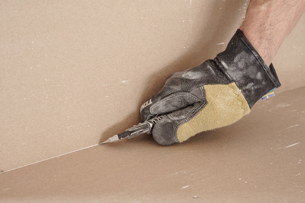 Un uomo con un paio di guanti da lavoro ai piedi