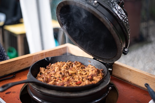 A rustic cast iron skillet sizzling with a hearty West Texas stew, set on a weathered wooden table.