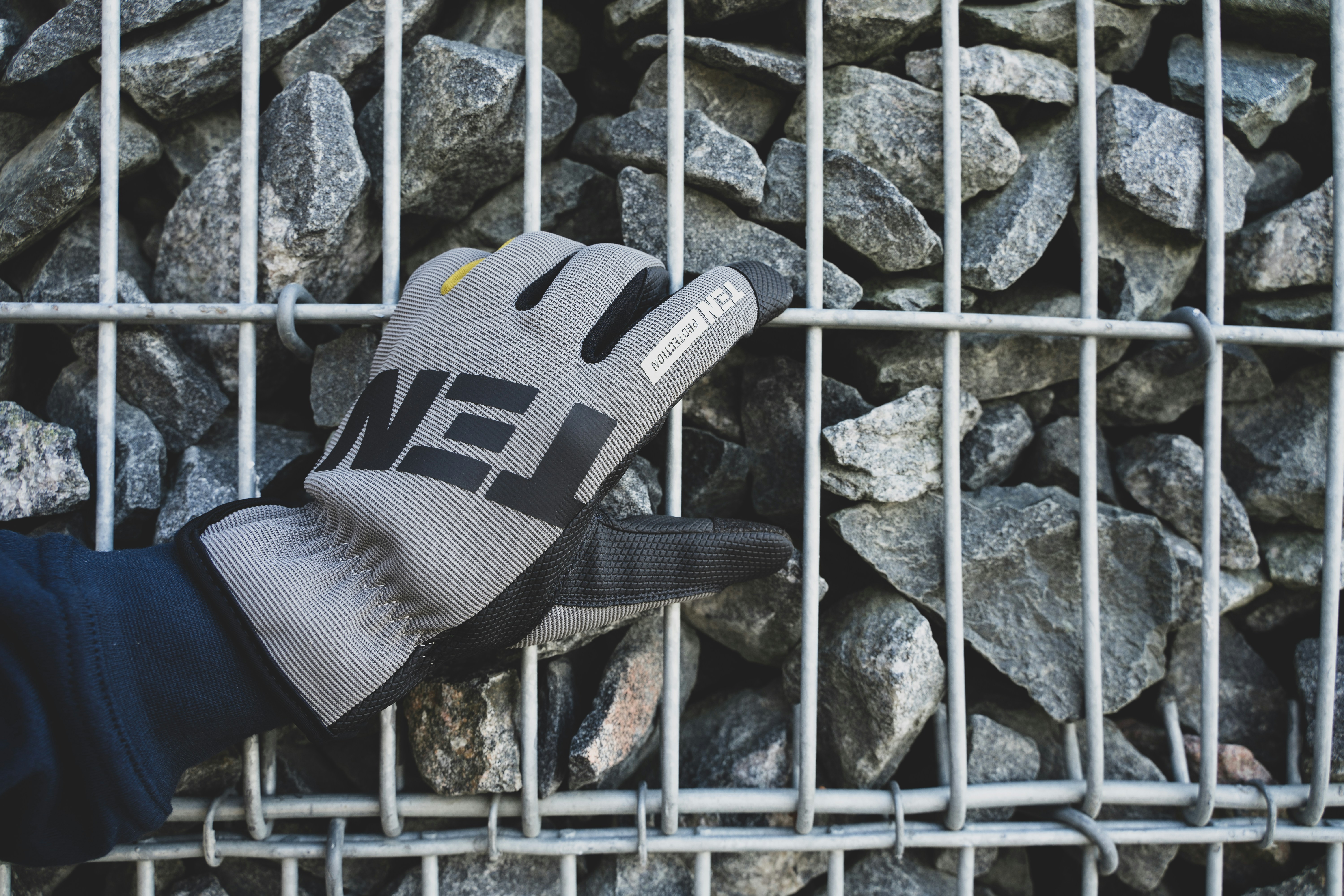 a person holding a glove over a pile of rocks