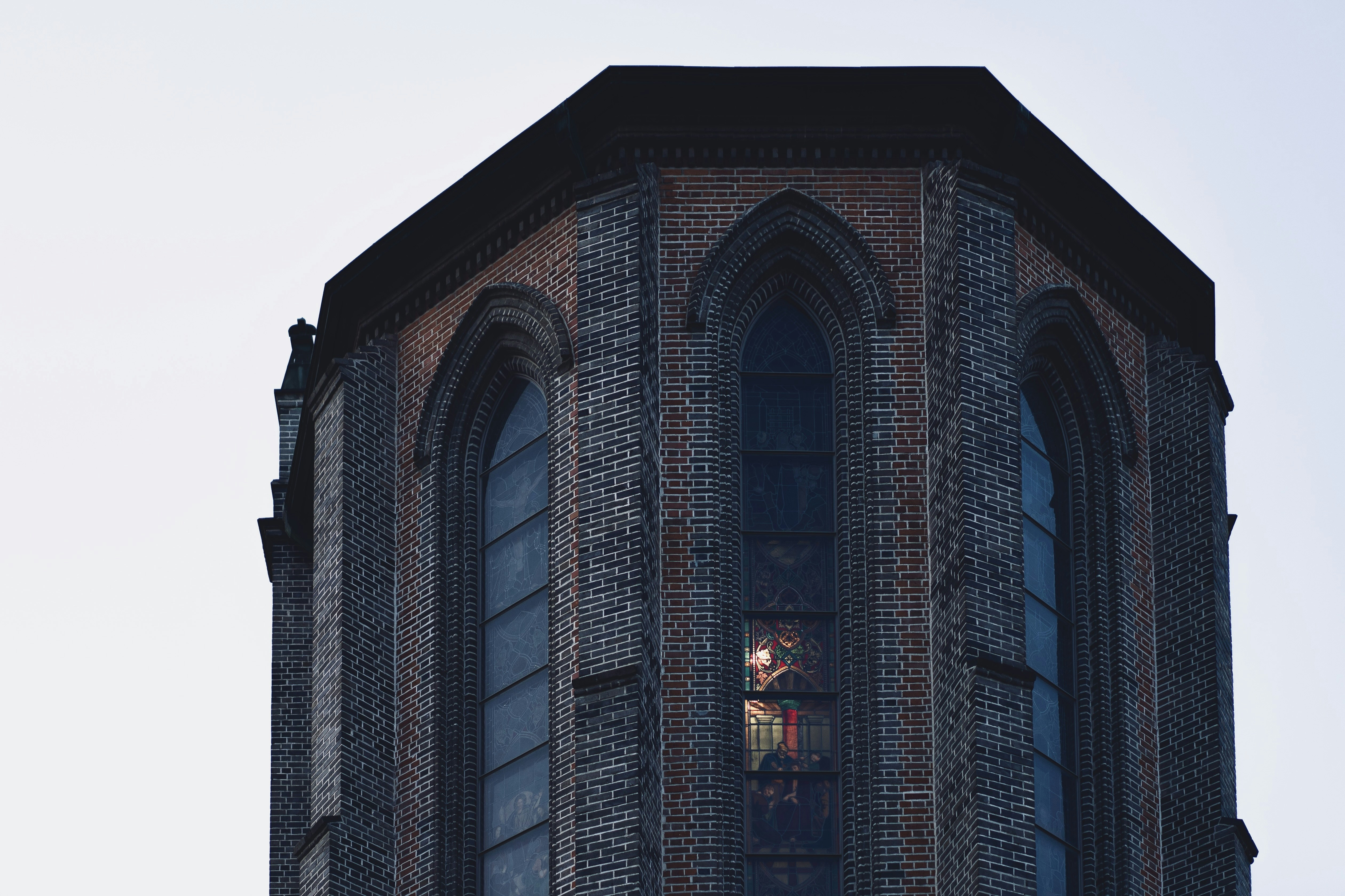 a tall brick building with a clock on it's side