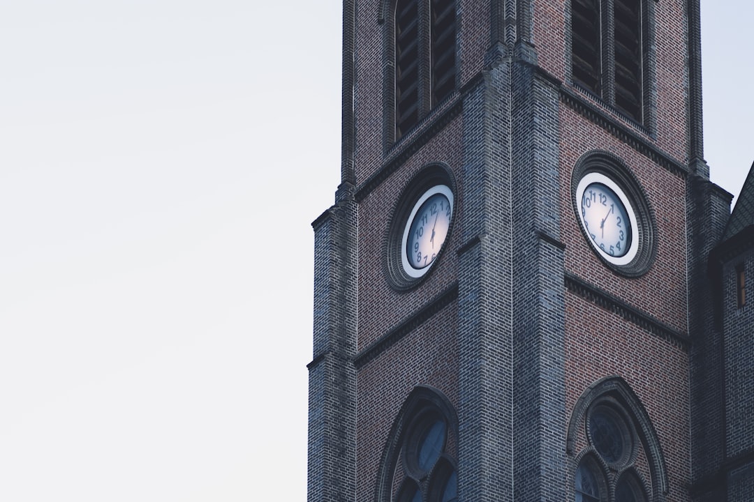 a tall clock tower with two clocks on each of it