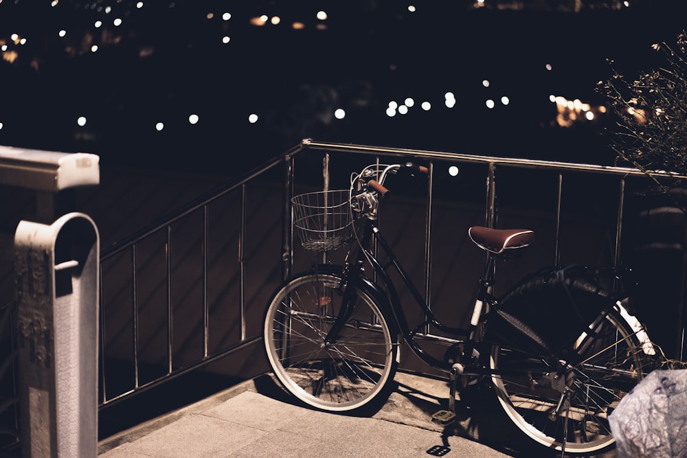 una bicicletta parcheggiata su un balcone che si affaccia su una città di notte