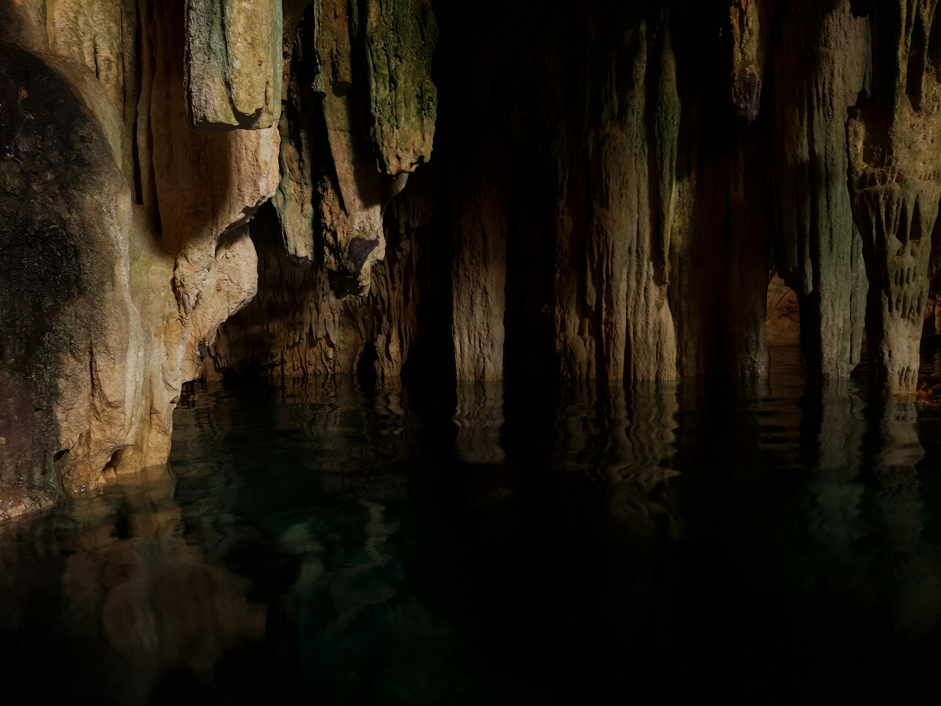 a cave filled with lots of water surrounded by rocks