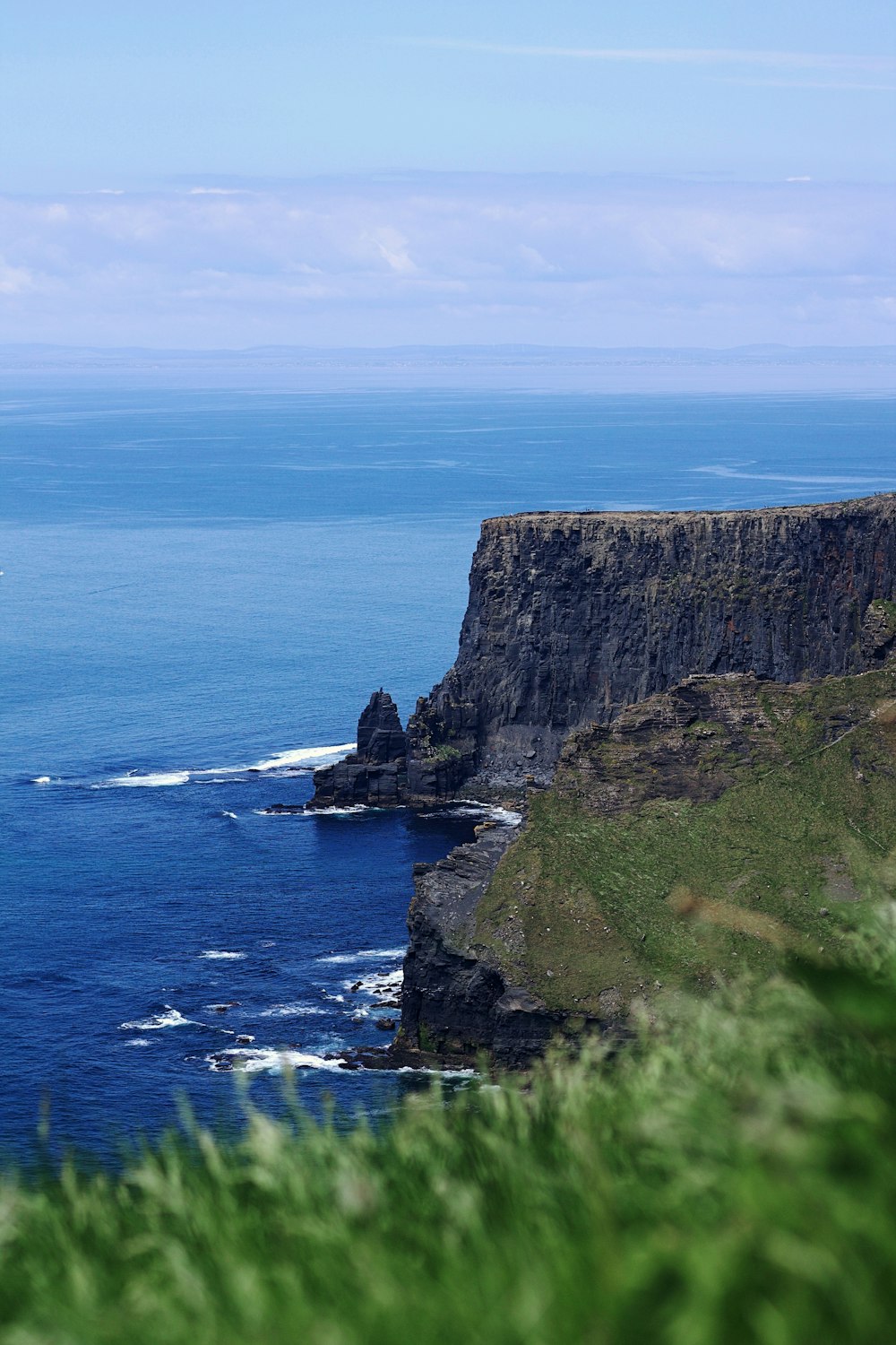 a large body of water sitting next to a lush green hillside