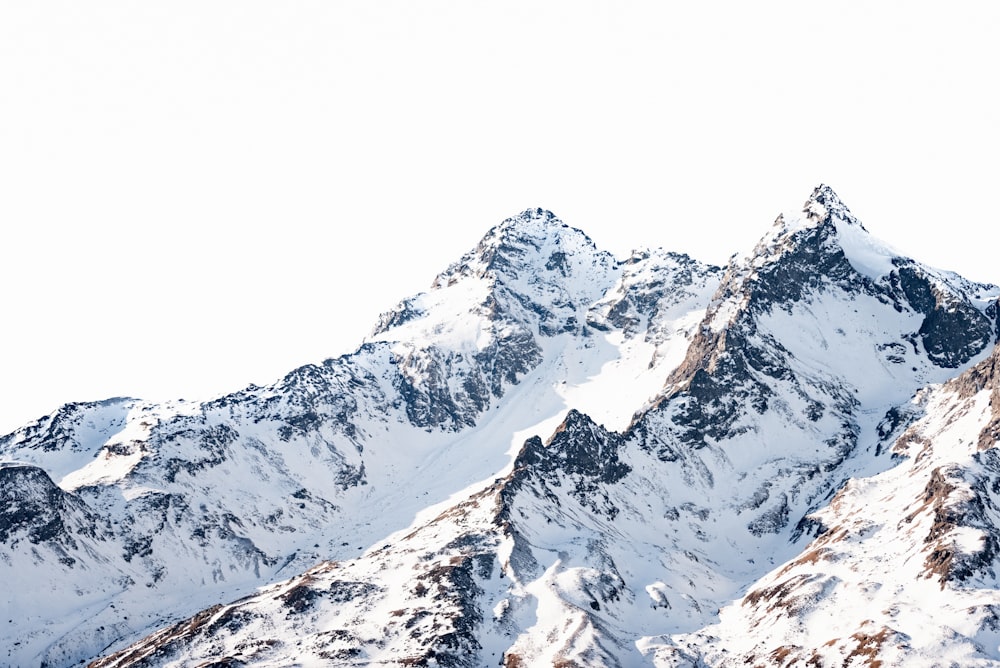 Ein Snowboarder steht auf dem Gipfel eines Berges