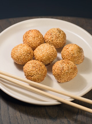 a white plate topped with meatballs and chopsticks