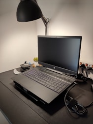 A tidy workspace featuring a laptop, decorative plants, and ambient lighting.