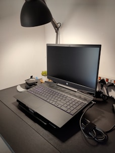 A tidy workspace featuring a laptop, decorative plants, and ambient lighting.