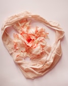 a white scarf with pink flowers on it