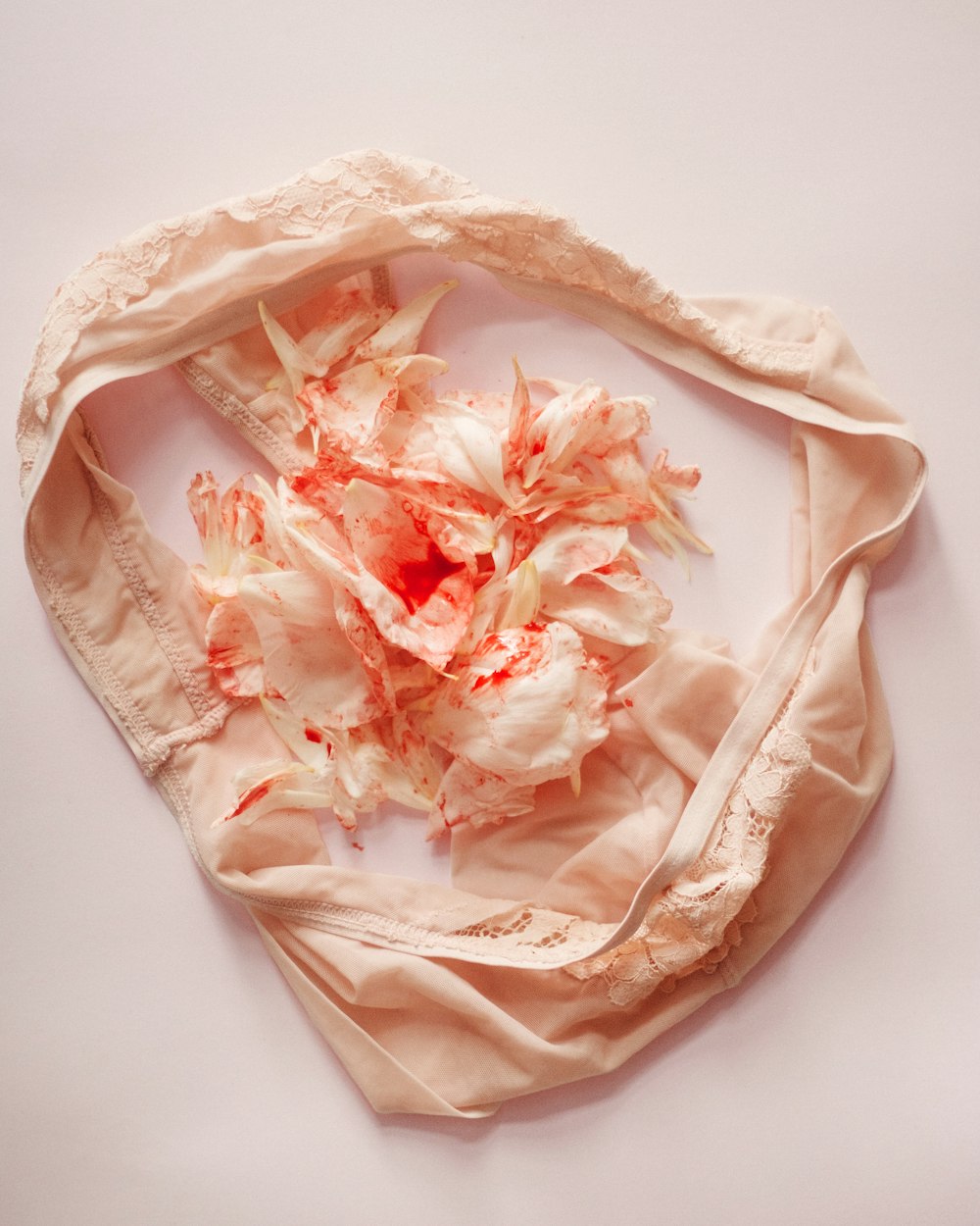 um lenço branco com flores cor-de-rosa sobre ele