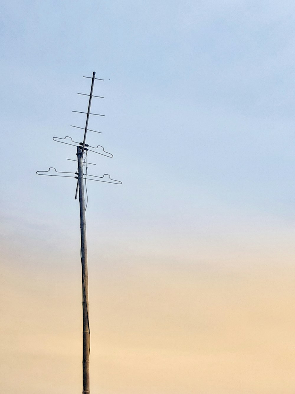 a tall wooden pole with a tv antenna on top of it
