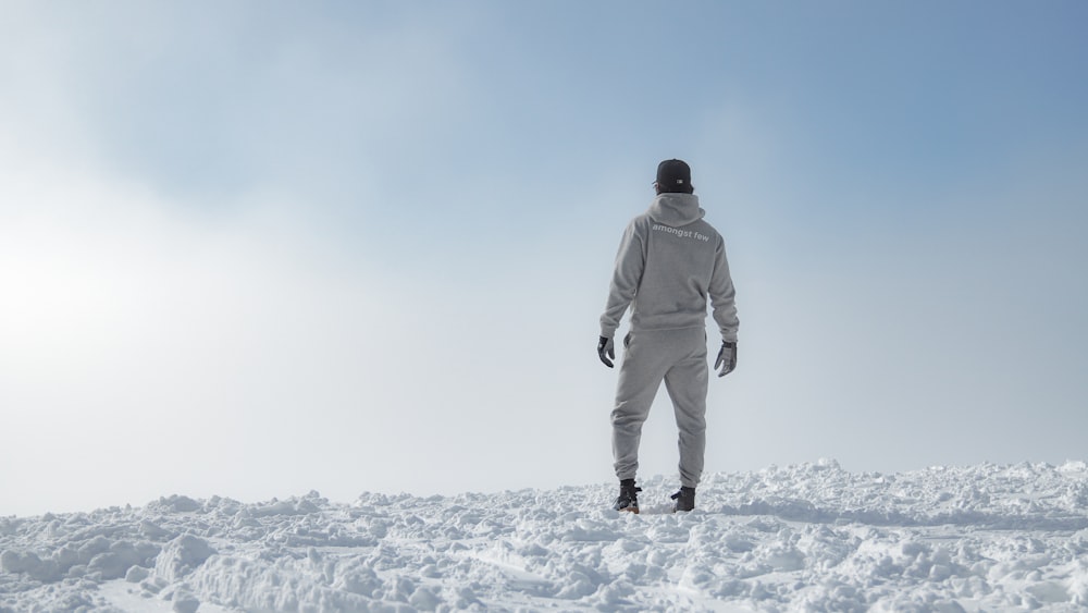 a man standing on top of a snow covered slope