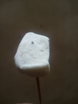 Close-up of a stack of colorful handcrafted marshmallows with a rustic wooden background.