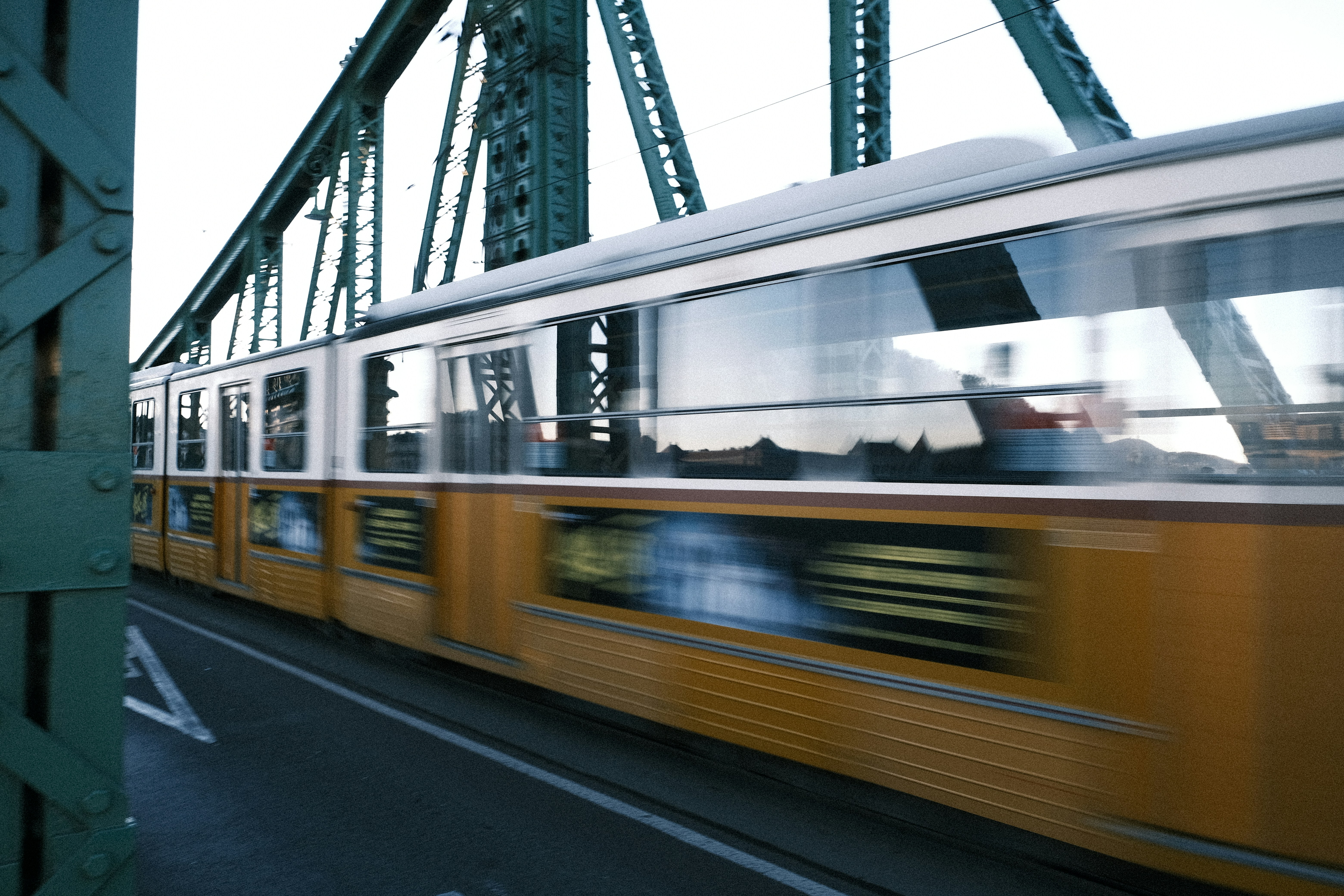 a yellow train traveling across a bridge over water