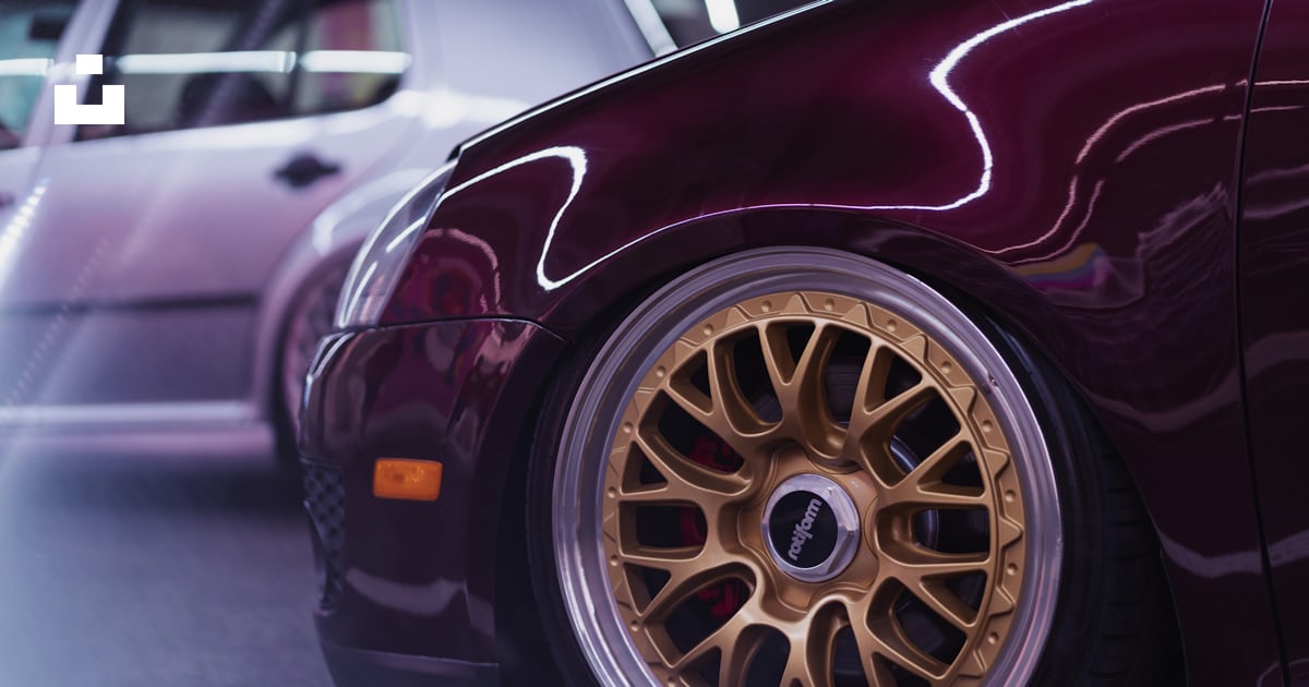 A maroon car with gold rims parked next to a white car photo – Free Usa ...