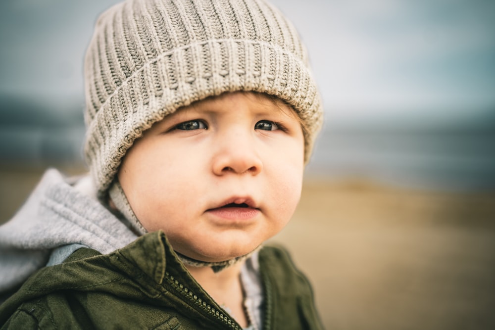 a little boy wearing a hat and jacket