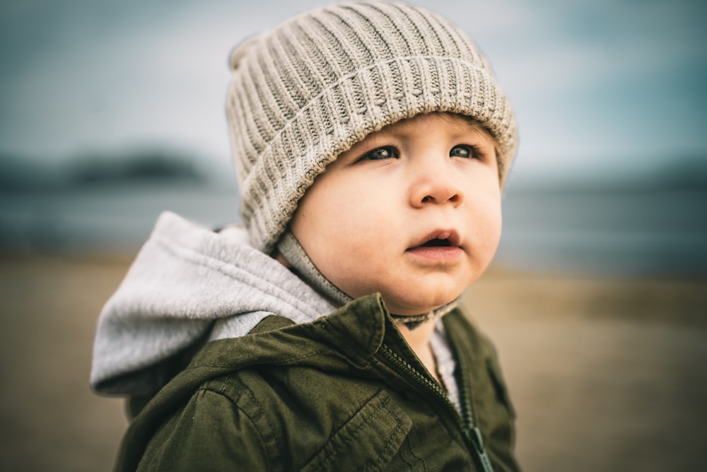 a small child wearing a hat and jacket