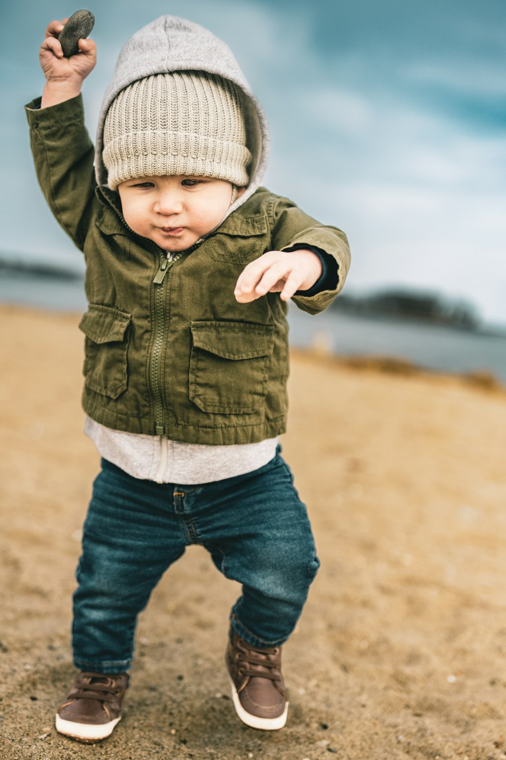 Ein kleiner Junge steht auf einem Sandstrand