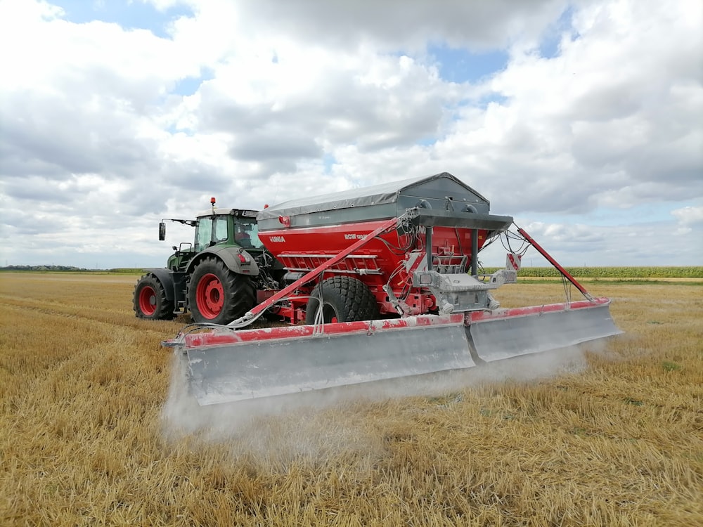 a red tractor is driving through a field