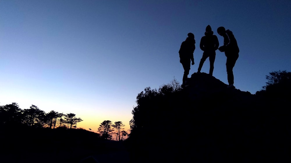 a group of people standing on top of a hill