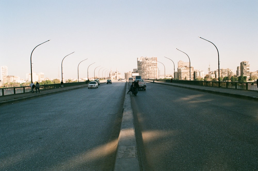 a man riding a motorcycle down a street next to tall buildings