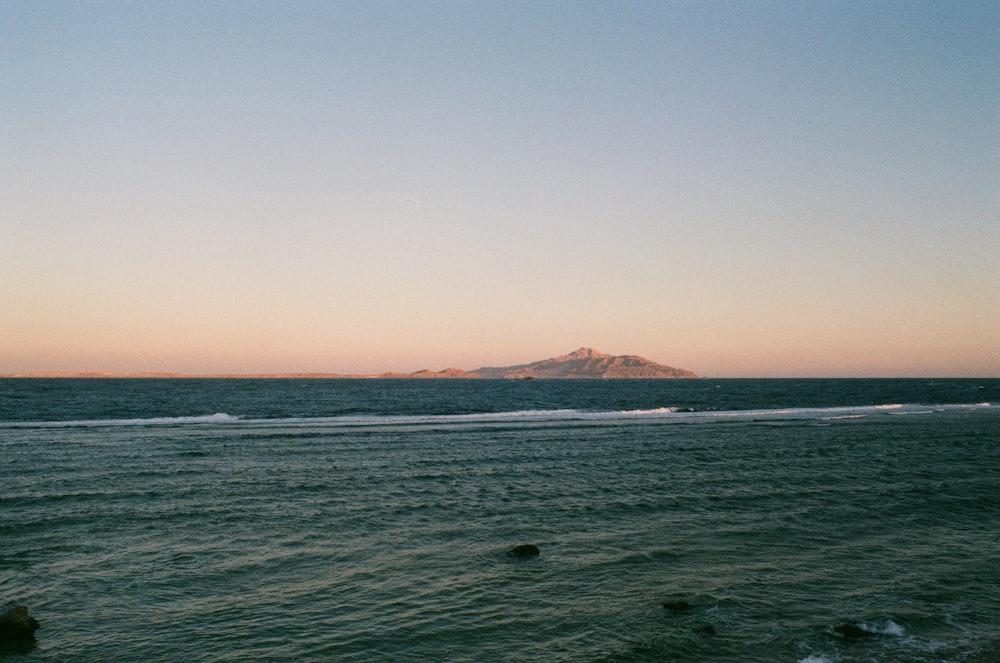 a large body of water with a small island in the distance