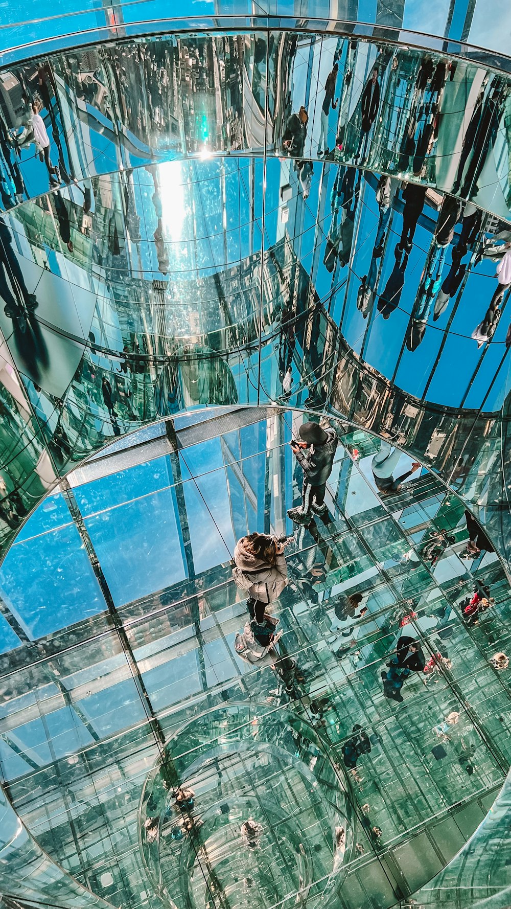 a reflection of people in a glass building