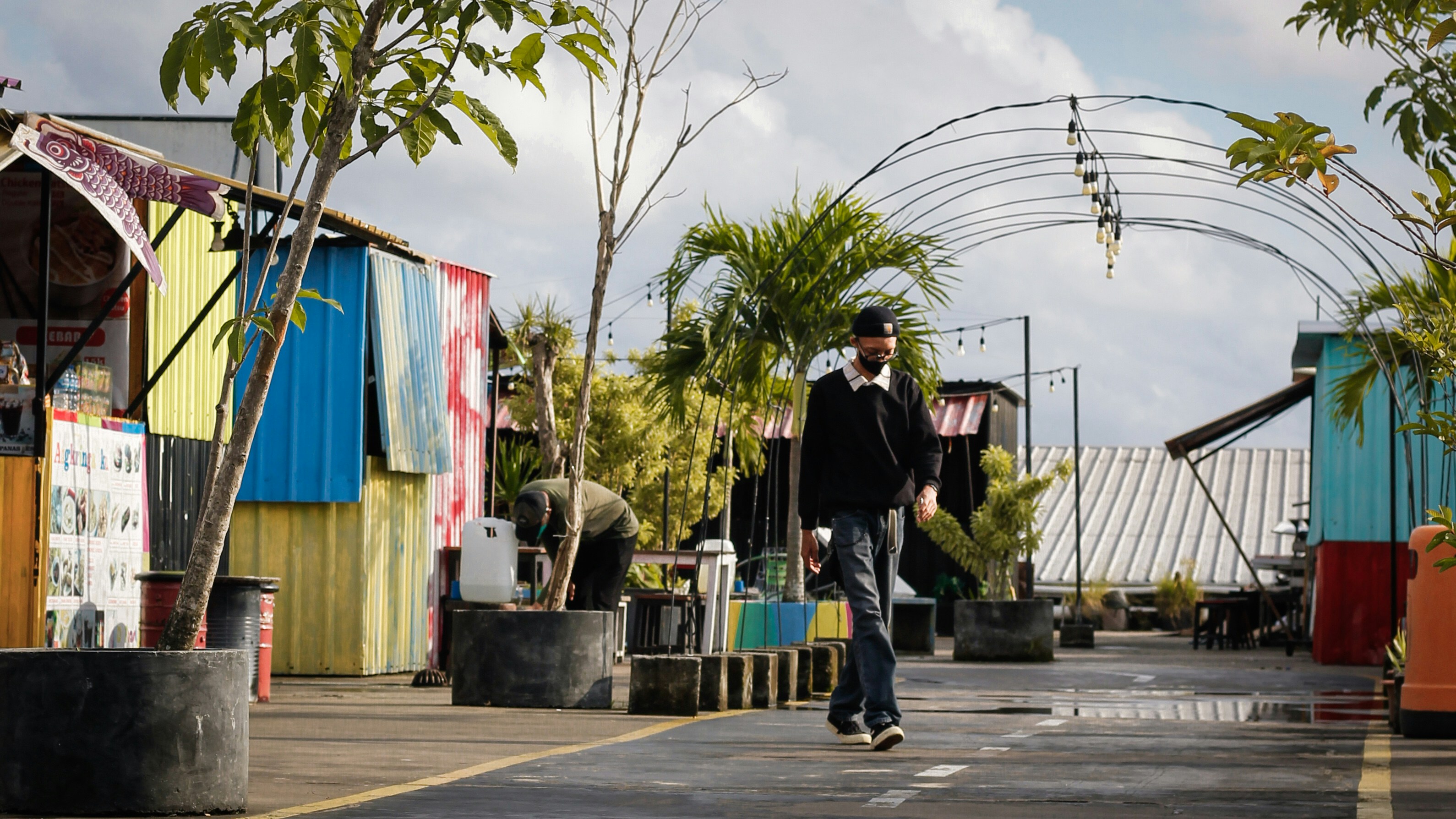 a man walking down a street next to colorful buildings