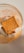 A square butter biscuit is placed inside a clear glass. The glass has orange text and a heart illustration on it. The biscuit is labeled 'LEIBNIZ BUTTERKEKS'.