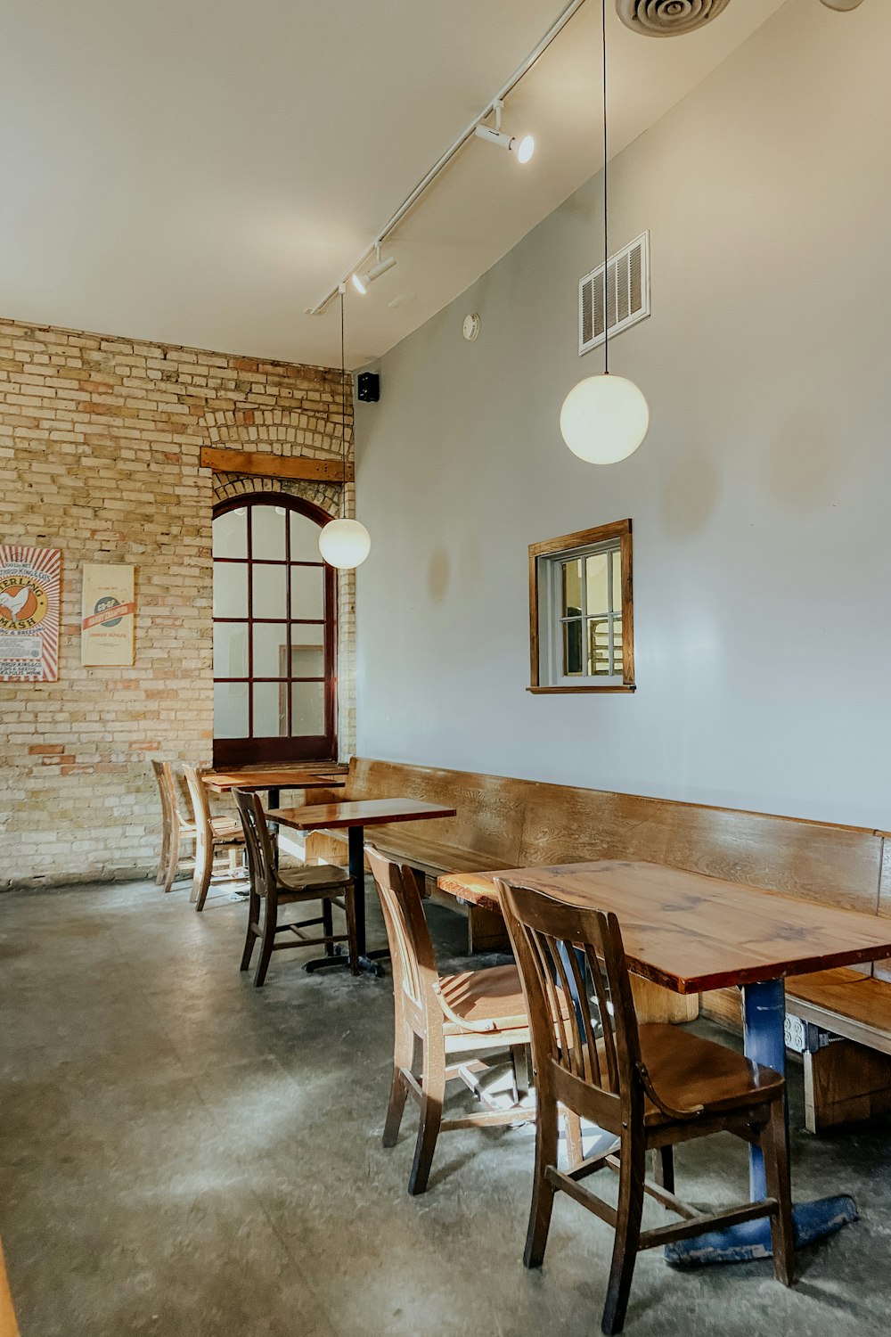 a restaurant with tables and chairs and a brick wall