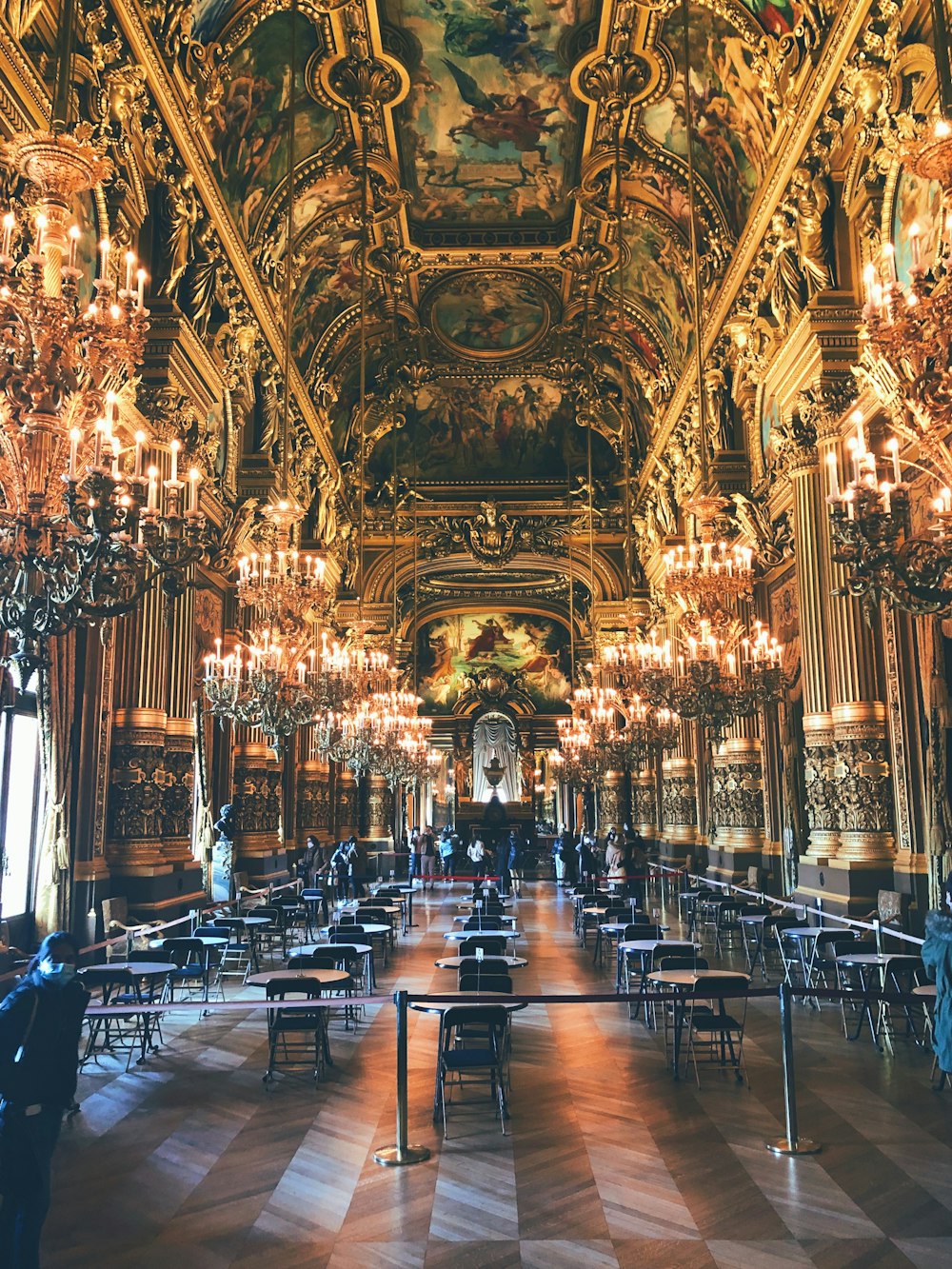 a large dining hall with chandeliers and tables