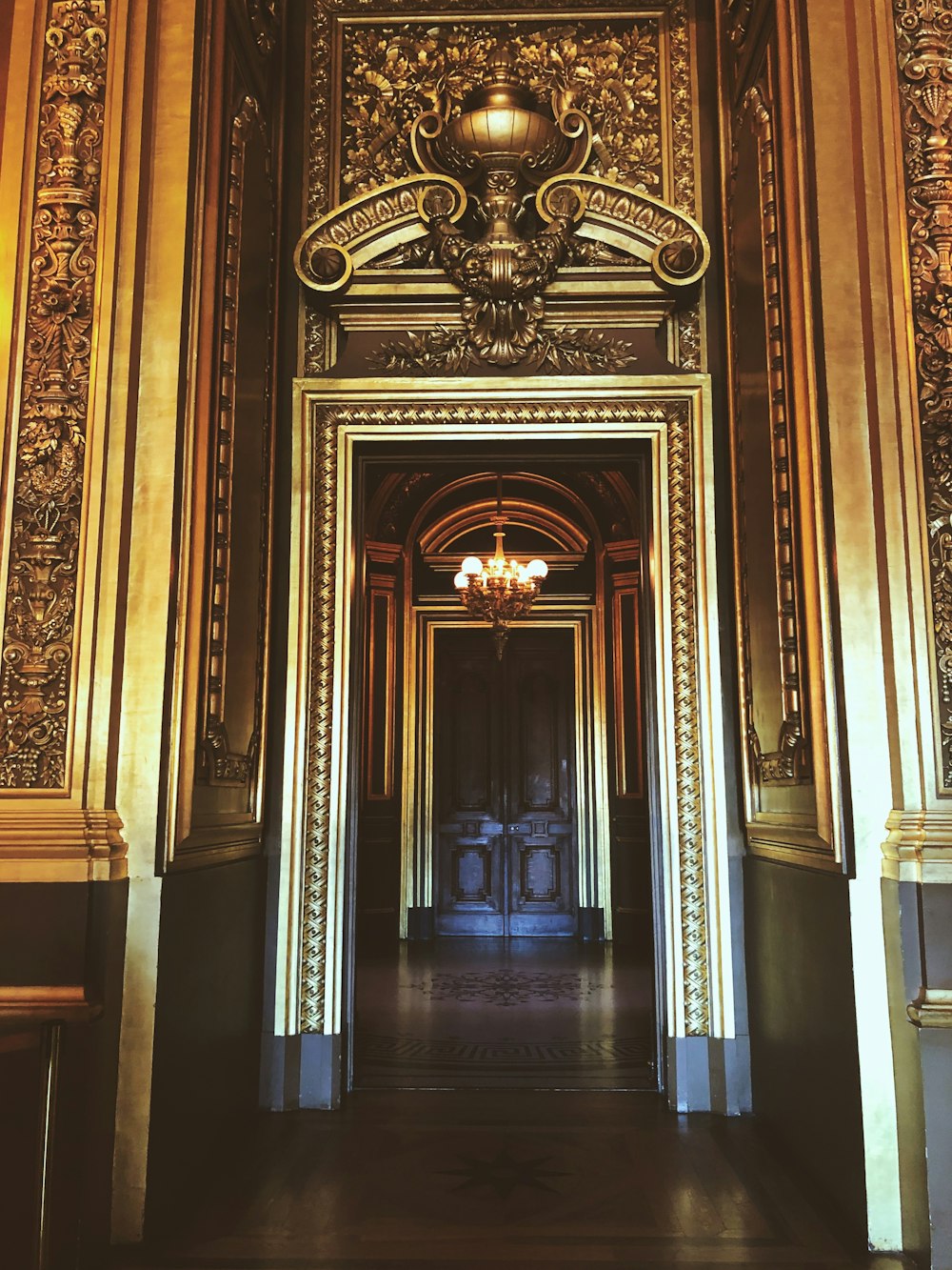 a long hallway with a chandelier hanging from the ceiling