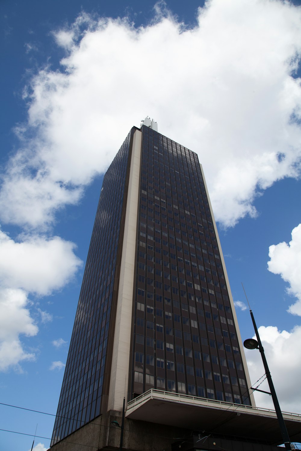 a very tall building sitting under a cloudy blue sky