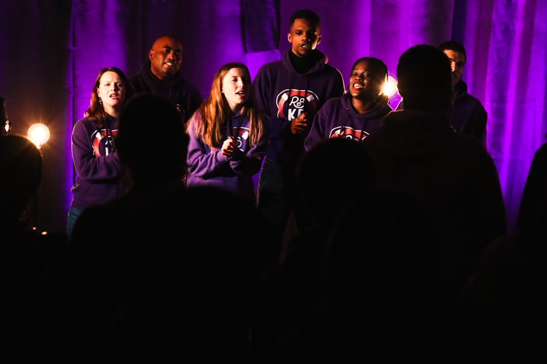 a group of people standing in front of a purple curtain