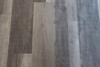 Different shades of grey and brown wooden planks arranged in a pattern with distinct wood grain textures visible.