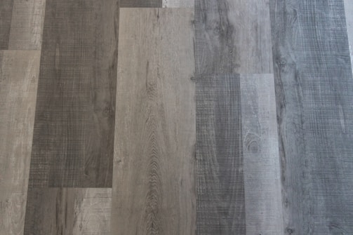 Different shades of grey and brown wooden planks arranged in a pattern with distinct wood grain textures visible.