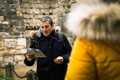 a man standing in front of a stone wall
