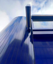 Exterior building design with sleek lines and blue accents under clear daylight.