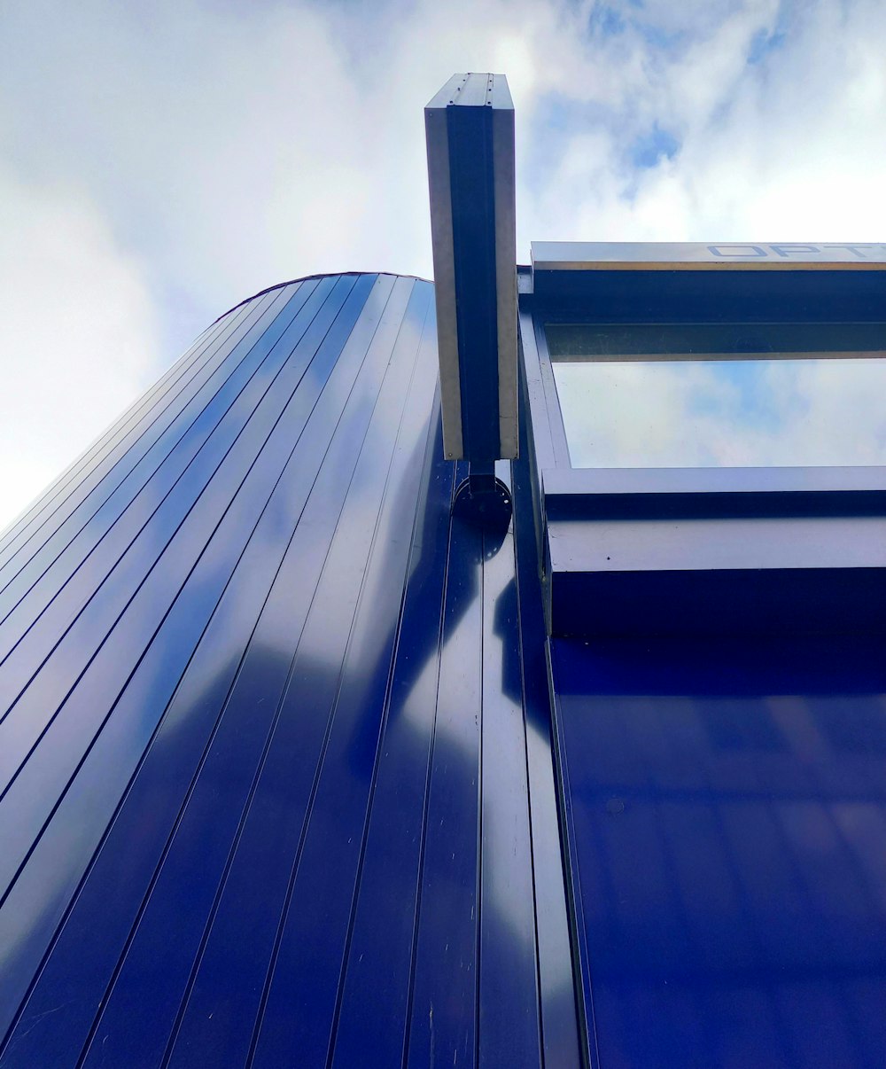 a close up of a blue building with a sky background