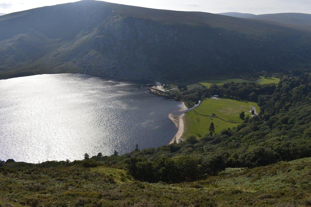 a large body of water surrounded by a lush green hillside